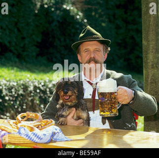 Mann mit Rauhaar Dackel im Biergarten Stockfoto