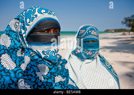 Verschleierte muslimische Frauen am Strand von Sansibar, Tansania, Afrika Stockfoto