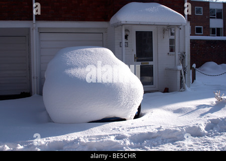 Schneebedeckte Auto auf einer Einfahrt Stockfoto