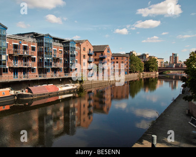 Fluss Aire in Leeds Großbritannien mit Wohnungen und Langbooten Stockfoto