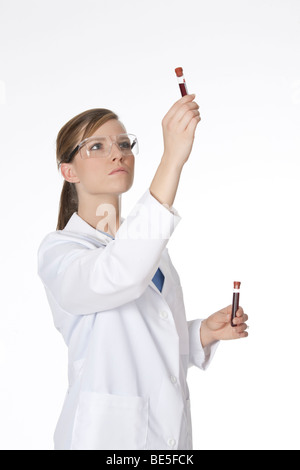 Schöne Labortechniker untersucht eine Röhre des Blutes Stockfoto