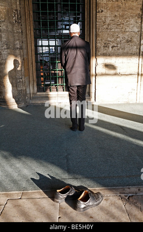 Muslimischen Mann in einem Anzug betet vor einer Moschee Schuhe ausgezogen, Iskele, Mirimah-Sultan-Moschee, Ueskuedar, Istanbul, Türkei Stockfoto