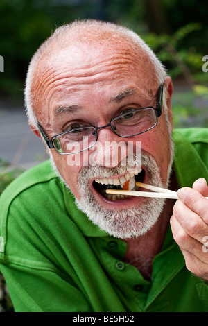 Ein älterer Mann Essen sushi Stockfoto