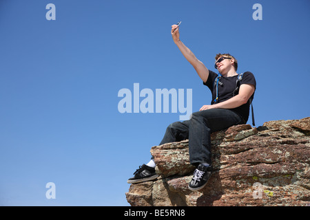 Junger Mann unter Selbstportrait auf Klippe Stockfoto