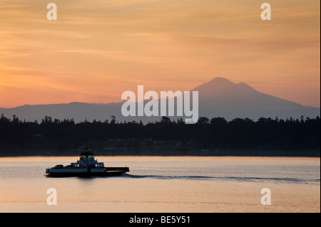 Sonnenaufgang über dem Mt. Baker, Washington und der Lummi Island Fähre. Die Fähre verkehrt zwischen Lummi Island und der Stachelbeere-Punkt. Stockfoto