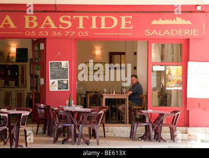 Ein einsamer Mann sitzt beim Mittagessen mit Wein in einer Bar, Monflanquin, Aquitaine, Frankreich Stockfoto
