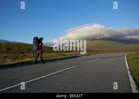 Männliche Wanderer auf leere Bergstraße, Isle Of Skye, Schottland Stockfoto