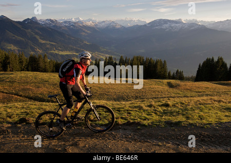 Mountainbiker am Berg Hohe Salve, dem Großvenediger-Berg im Rücken, Tirol, Österreich, Europa Stockfoto