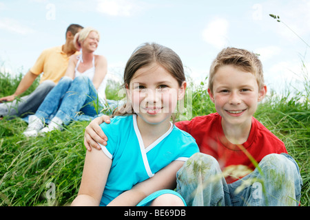 Familie sitzen auf einer Wiese, Blick in die Ferne Stockfoto