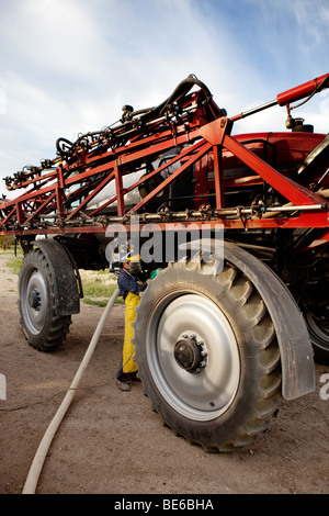 Ordnungsgemäße Sicherheitsausrüstung einfüllen Chemikalie in eine hohe Bodenfreiheit Spritze. Stockfoto