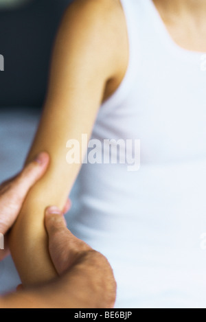 Masseurin massiert Frau Arm abgeschnitten Stockfoto