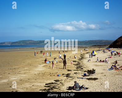 Sandstrand mit Menschen am Strand mit Blauer Flagge bei Ebbe im Frühsommer. Benllech, Isle of Anglesey, North Wales, UK, Großbritannien Stockfoto