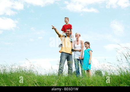 Glückliche Familie stehen auf einer Wiese, Blick in die Ferne Stockfoto