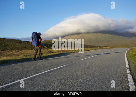 Männliche Wanderer auf leere Bergstraße, Isle Of Skye, Schottland Stockfoto