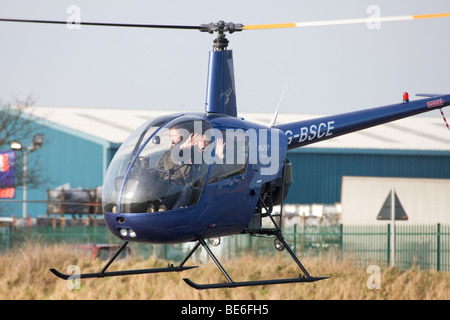 Robinson R22 Beta G-BSCE im Flug abheben vom Sandtoft Flugplatz Stockfoto