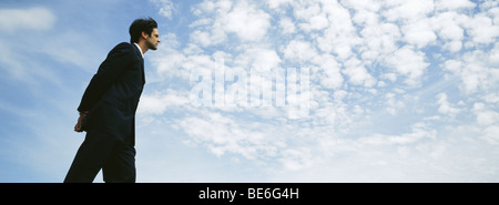 Walking im Freien mit Händen hinter niedrigen Winkel Ansicht, Geschäftsmann Stockfoto