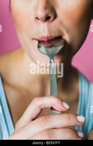 Frau lecken Löffel, beschnitten Stockfoto