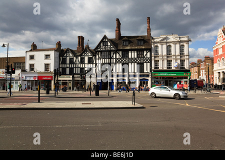 Straßenkreuzung auf Clapham High Street mit Geschäften hinter und ein Auto drehen in eine gelbe Box Junction, London, UK Stockfoto