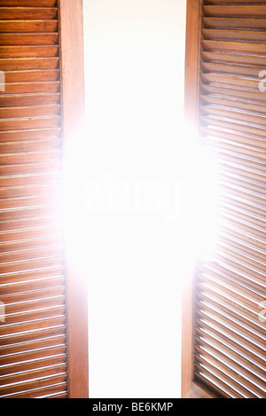 Fensterläden aus Holz, teilweise geöffnet, hellem Sonnenlicht Stockfoto