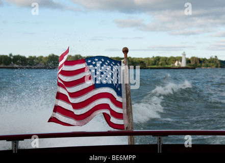 Vom Wind verwehten US-Flagge in Motorboote wecken. Stockfoto