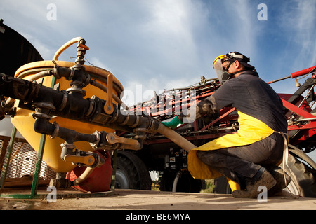 Ein Mann, ein hoher Bodenfreiheit Sparying mit guten Chemikaliensicherheit zu füllen Stockfoto