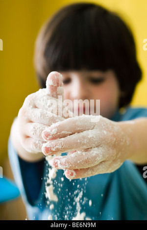 Kleiner Junge spielt mit Mehl Stockfoto