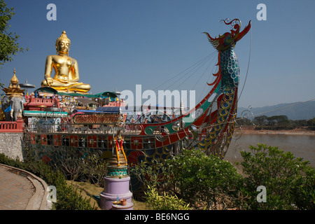 Goldene Statue von Buddha und stilisierte Stahl Boot auf dem Mekong River, goldenen Dreieck zwischen Thailand, Myanmar und Laos, Sop-Ru Stockfoto