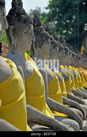 Buddha-Statuen durch die große Chedi Chaya Mongkol, Wat Yai Chai Mongkon, Ayutthaya, Thailand, Asien Stockfoto