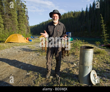 Mann mit Räucherfisch, Raucher, arktische Äsche (Thymallus Arcticus), oben Liard River, Yukon Territorium, Kanada Stockfoto