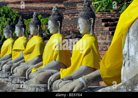 Buddha-Statuen durch die große Chedi Chaya Mongkol, Wat Yai Chai Mongkon, Ayutthaya, Thailand, Asien Stockfoto