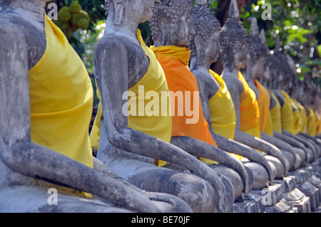 Buddha-Statuen durch die große Chedi Chaya Mongkol, Wat Yai Chai Mongkon, Ayutthaya, Thailand, Asien Stockfoto