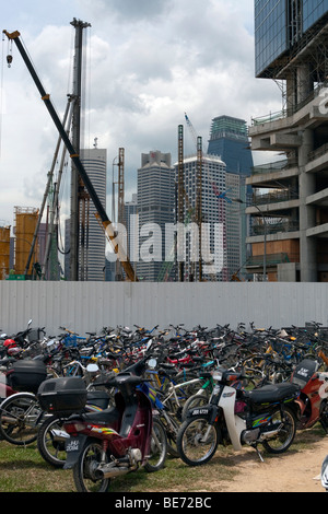 Fahrräder und Motorroller vor einer Baustelle Bauboom in Singapur, Asien Stockfoto