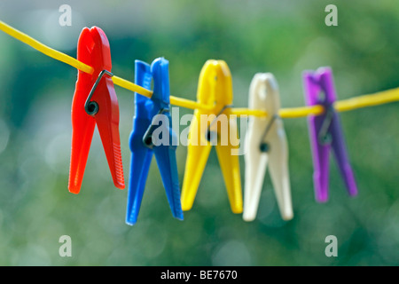 mehrfarbige Wäscheklammer auf gelbe Wäscheleine, Nahaufnahme Stockfoto