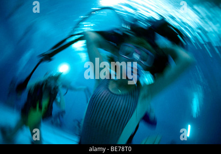 Tauchlehrer mit Druckluft Ausrüstung und Student Taucher in einem Pool, Panik unter Wasser Stockfoto