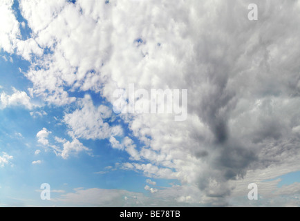 blauer Himmel mit großen weiß/grauen Wolken vorne Stockfoto