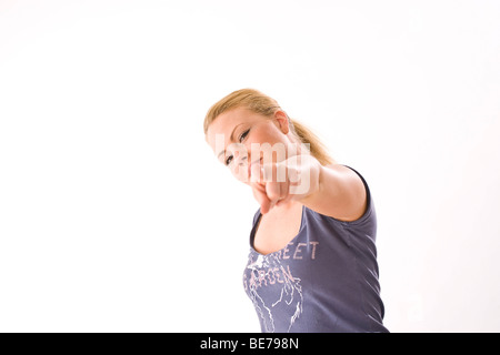 Junge blonde Frau zeigt auf die Kamera Stockfoto