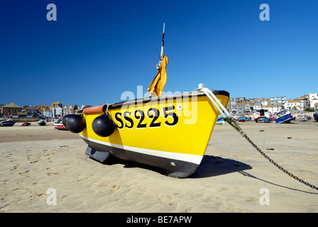 Gelbe Fischerboot gestrandet auf dem Sand in einem Hafen bei Ebbe Stockfoto