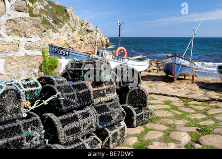 Hummer-Körbe auf einem Kai mit Fischerbooten im Hintergrund Stockfoto