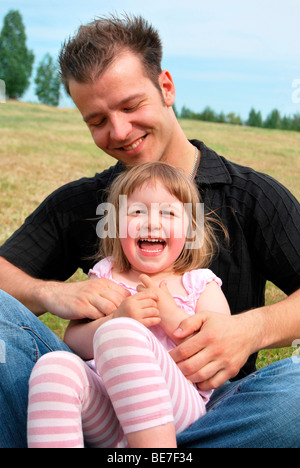 Alleinerziehender Vater kitzelt sein Kind Stockfoto