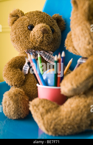 Teddybären von Angesicht zu Angesicht Tasse Buntstifte dazwischen sitzen Stockfoto