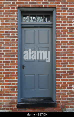 Alte graue Tür aus einem historischen Haus mit Mauer Stockfoto