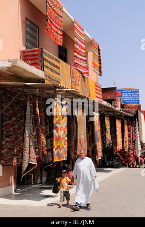 Marokko; Marrakesch; Place Rahba Kedima; Mann und der junge außerhalb Teppichgeschäft Stockfoto