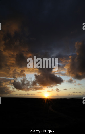 Den Sonnenuntergang mit einem spektakulären Himmel über der Küste der Nordsee Stockfoto