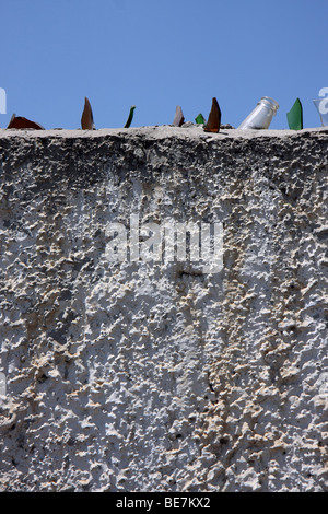 Eine Wand mit scharfen Glassplitter aus zerbrochenen Flaschen als Schutz gegen Menschen klettern über die Mauer, Nicosia Zypern Stockfoto