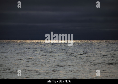Sonnenlicht durchbricht Gewitterwolken, auf hoher See Stockfoto