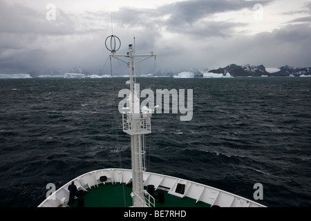 Antarktis Kreuzfahrt Schiff segelt in Richtung herannahenden Sturm und Meer von großen Eisberge in eisbergs Gasse in der Nähe von South Georgia Southern Ocean 1 Passagier auf Bug Stockfoto