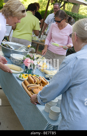 Nachbarschaft Picknick buffet Tisch mit Hot Dogs, Hamburger, Bbq Chicken Maiskolben. Stockfoto