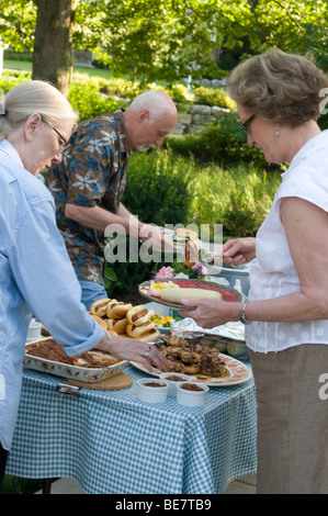 Nachbarschaft Picknick buffet Tisch mit Hot Dogs, Hamburger, Bbq Chicken Maiskolben. Stockfoto