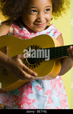 Kleine Mädchen spielen kleine Gitarre Stockfoto