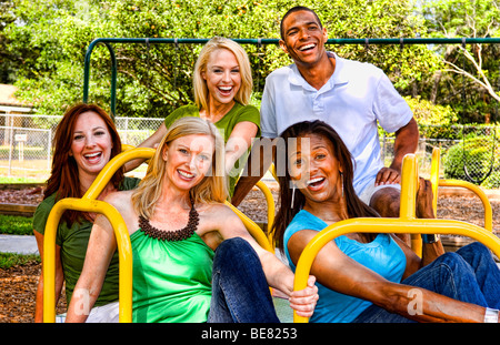 Große Gruppe von gemischten ethnischen Freunde Spaß undf Lachen am Spielplatz auf Fahrt im Freien bei Sonnenschein Stockfoto